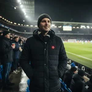 A spectator wearing a battery-heated coat while sitting in the stands at a football match.