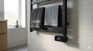 A stylish matt black electric towel radiator mounted against a light grey feature wall in a UK home.