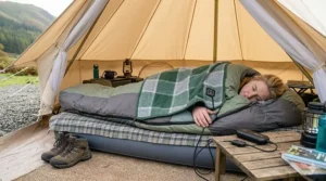 A heated camping blanket used as an extra layer inside a double sleeping bag on a camping pitch.