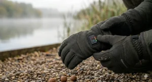 Close-up of the smart LED power button and battery life indicator on the cuff of a heated fishing glove.
