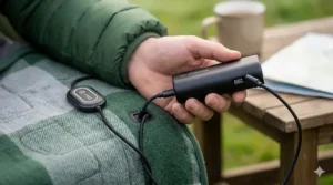 Close-up illustration of a power bank connecting to a heated camping blanket via USB port.