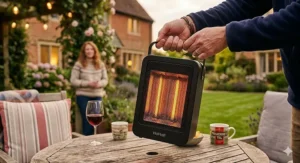 A person carrying a lightweight, small patio heater for table using the integrated handle.