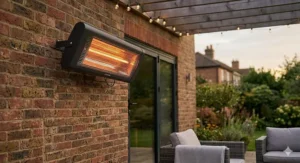 A black wall-mounted electric patio heater providing targeted warmth to an outdoor seating area, securely installed on a traditional brick wall.