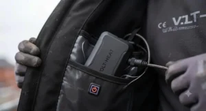 Close-up of a rechargeable battery pack connected inside the pocket of a heated work jacket.