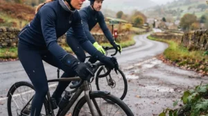 Commuter cyclist navigating a wet British road wearing high-visibility heated cycling gloves.