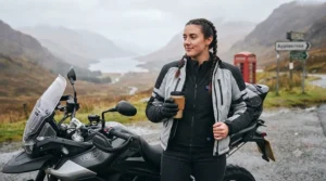 Adventure motorcycle rider taking a break on a touring trip while wearing a heated motorcycle vest.