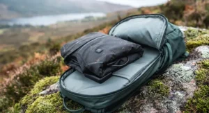 A packable heated cycling jacket neatly folded inside an open MTB backpack ready for changing weather.