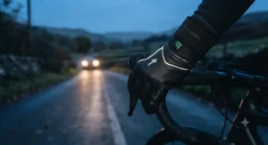 Reflective safety details glowing on heated cycling gloves for road cyclists during low-light evening rides.