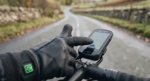 A cyclist using a GPS bike computer while wearing touchscreen-compatible heated cycling gloves for road cyclists.