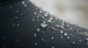 Water-resistant neoprene fabric detail showing rain beads rolling off winter cycling overshoes.