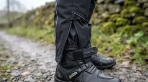 Motorcycle tourer preparing for a cold-weather ride wearing waterproof heated trousers and jacket gear.