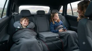 Passengers staying cozy in the back seats of a car using a 12V heated car blanket on a winter journey